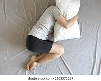 Overhead view of unhappy depressed young woman lying on bed in bedroom, suffering from depression, upset, suffering from emotional breakdown or crisis, healthcare concept - Shutterstock ID 2363371269