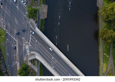 An Overhead View Of Unidentifiable Rowers On The Yarra River And Cars On Swan Street Bridge In Melbourne, Australia