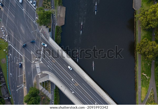 An overhead\
view of unidentifiable rowers on the Yarra River and cars on Swan\
Street Bridge in Melbourne,\
Australia