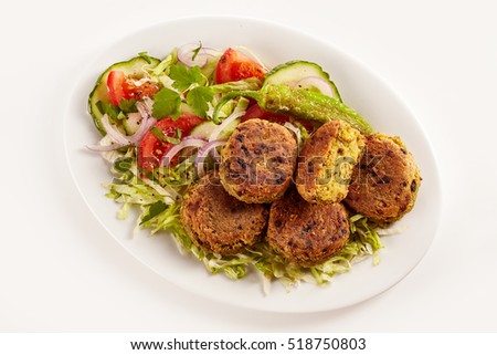 Overhead view of vegetarian chickpea patties set on a bed of lettuce in an oval plate against a white background Stock photo © 
