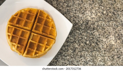 Overhead View Of Waffles On A White Plate On A Kitchen Counter With Copyspace