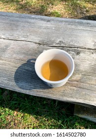 Overhead View Of Warm Plant Tea Cup On The Wooden Bench In Garden