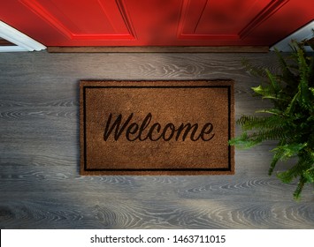 Overhead view of welcome mat outside inviting front door of house with potted fern plant