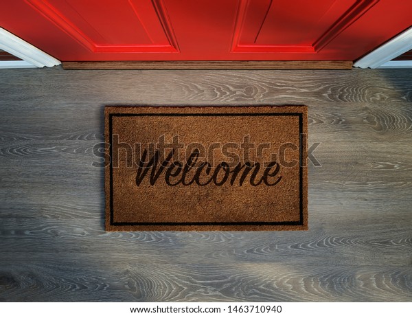 Overhead view of welcome mat outside inviting front\
door of house