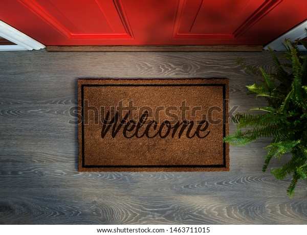 Overhead view of welcome mat outside\
inviting front door of house with potted fern\
plant