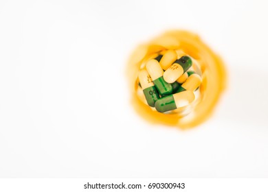 Overhead View Of White And Blue Pills Or Capsules In Orange Prescription Bottle