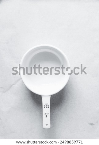 Overhead view of white ceramic measuring cup, top view of measuring cup with a handle 