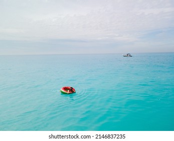 Overhead View Of Woman Floating On Inflatable Ring In Blue Sea Water Sunbathing