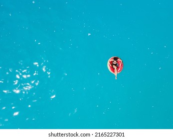 Overhead View Of Woman Floating On Inflatable Ring In Blue Sea Water Sunbathing