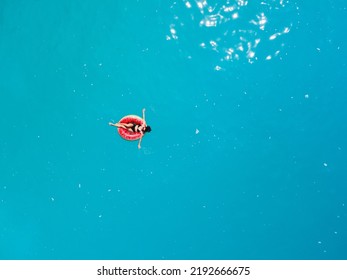 Overhead View Of Woman Floating On Inflatable Ring In Blue Sea Water Sunbathing