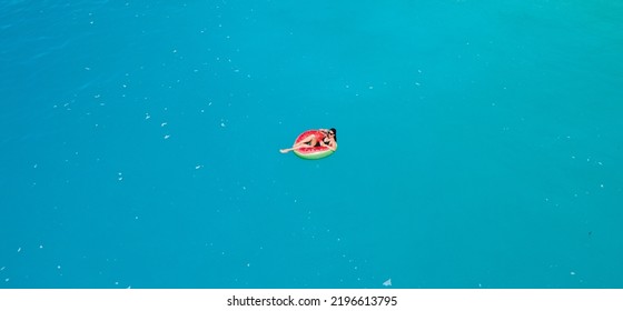 Overhead View Of Woman Floating On Inflatable Ring In Blue Sea Water Sunbathing