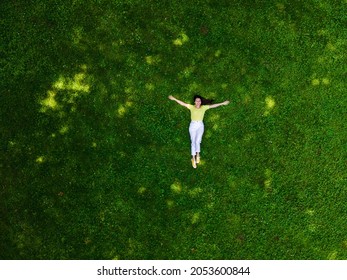 Overhead View Of Woman Laying Down On Green Grass Summertime