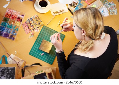 Overhead View Of Woman Making Jewelry At Home