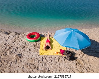 Overhead View Woman Sunbathing At Sandy Beach Blue Lake Water Copy Space