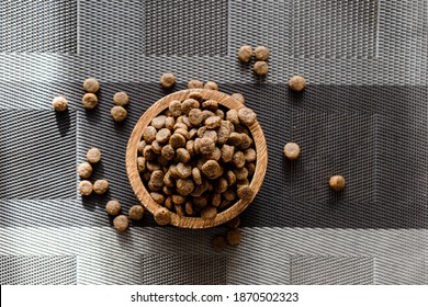 Overhead View Of A Wood Bowl Of Dry Food On A Brown Checkered Background. Pet Food.