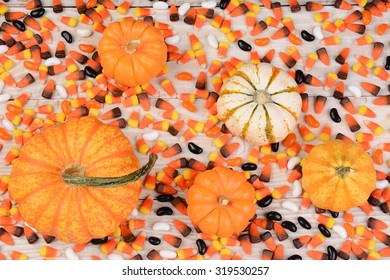 Overhead View Of A Wood Table Covered With Candy Corn And Decorative Pumpkins And Gourds. Great For Halloween Or Thanksgiving Projects.