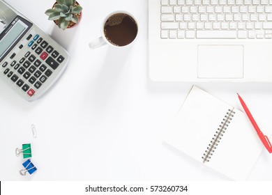 Overhead View Of Working Desk With White Laptop Computer, Calculator, Cup Of Coffee, Succulent Plant And Notebook