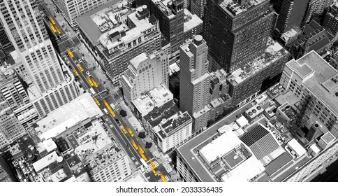 Overhead view of yellow taxis driving through the black and white buildings of Midtown Manhattan in New York City NYC