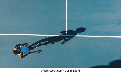 Overhead view of young african american female tennis player with shadow playing on blue court. unaltered, sport, competition and tennis game concept. - Powered by Shutterstock