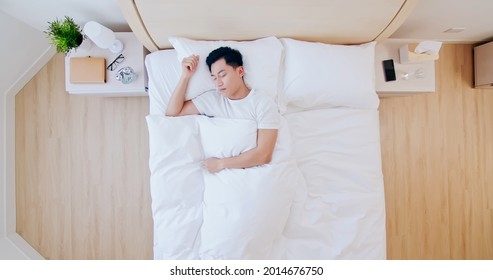 Overhead View of young asian man sleeping well and relaxing in the morning