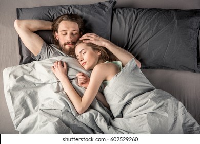 Overhead View Of Young Couple Sleeping In Bed