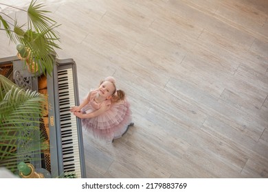 Overhead view of young girl playing grand piano in sunlight room