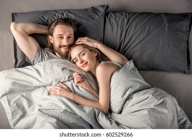 Overhead View Of Young Happy Couple In Love Lying In Bed