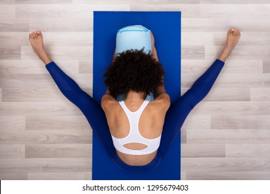 An Overhead View Of A Young Woman Sitting On Blue Exercise Mat Doing Yoga