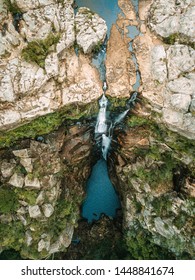 Overhead Views Of Waterfall Flowing Over Cliffs 100 Metres  To A Rock Pool At The Base In Australian Bushland