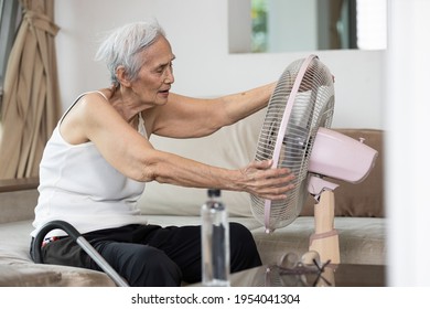 Overheated Asian Senior Woman Sweating,high Temperature In Sunny Day While Stay At Home,cooling Herself In Front Of An Electric Fan,old Elderly Suffering From Heat,hot Summer Weather,lifestyle Concept