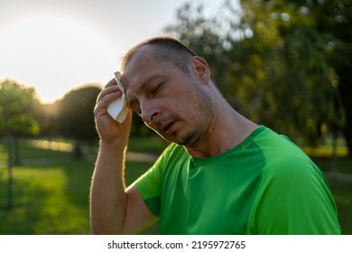 Overheated Sweaty Middle Aged Man Suffering From Heat Stroke Or High Temperature, Using Paper Napkin In Summer Park. Head Shot Close Up Portrait Tired Guy Feeling Unhealthy