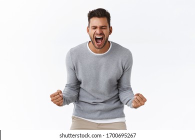 Overjoy, success and life goals concept. Ecstatic pleased and delighted good-looking man scream from happiness, heard great news, achieve success, winning, become champion, got reward - Shutterstock ID 1700695267