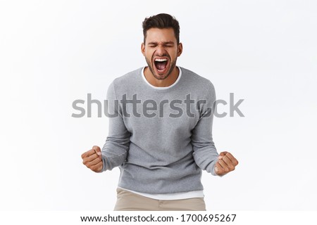 Overjoy, success and life goals concept. Ecstatic pleased and delighted good-looking man scream from happiness, heard great news, achieve success, winning, become champion, got reward