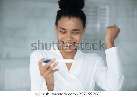 Overjoyed african American young woman do quick medical ovulation pregnancy test in bathroom, get positive result, happy biracial female excited getting pregnant, maternity, fertility, ivf concept Stock photo © 