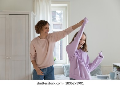 Overjoyed Caucasian Mom And 13s Teen Daughter Have Fun Dance On Weekend In Home Bedroom. Happy Loving Play Mother And Teenager Child Feel Playful Engaged In Funny Activity, Enjoy Family Time Together.