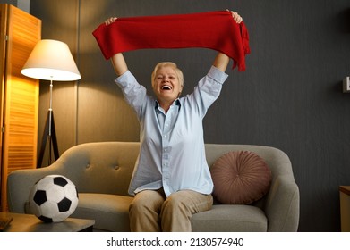 Overjoyed elderly football holding scarf over head - Shutterstock ID 2130574940