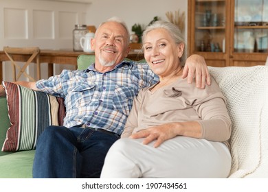 Overjoyed elderly husband and wife relax on couch having fun laughing together. Happy senior couple rest on sofa at home, smile and enjoy leisure. Family romantic weekend at home, mature love concept - Powered by Shutterstock