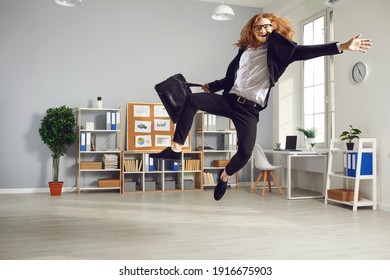 Overjoyed Employee Leaving Office At The End Of Day. Young Man Having Fun As It's Time To Finish Work. Funny White-collar Worker Is So Happy That Workday Is Over That Is Jumping High Ready To Fly Home