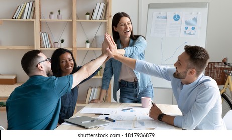 Overjoyed Employees Team Giving High Five, Celebrating Success, Business Achievement, Great Teamwork Results, Standing In Modern Board Room, Engaged In Team Building Activity At Corporate Meeting