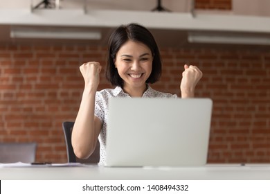 Overjoyed euphoric asian business woman worker feel winner celebrate online win looking at laptop computer, happy chinese student excited with great internet success professional triumph opportunity