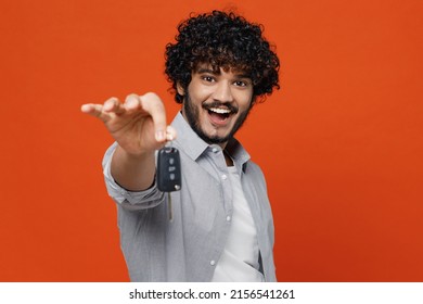 Overjoyed Excited Charming Smiling Charismatic Fun Driver Young Bearded Indian Man 20s Years Old Wears Blue Shirt Hold In Hand Show Give New Car Key Isolated On Plain Orange Background Studio Portrait