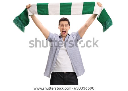 Overjoyed football fan holding a scarf and cheering isolated on white background