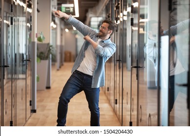Overjoyed funny male employee have fun perform winner dance in modern office hallway, excited happy millennial businessman celebrate business success or promotion, Friday evening, end of working week - Shutterstock ID 1504204430