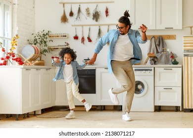 Overjoyed Happy African American Family Father And Little Son Dancing To Music In Modern Kitchen While Spending Time Together At Home, Child Boy Having Fun With Positive Daddy On Weekend