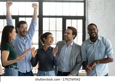 Overjoyed Happy Diverse Business Team Celebrating Success, Achievement Together, Laughing And Rejoicing, Smiling Excited Employees Colleagues Screaming With Joy, Standing In Office Room