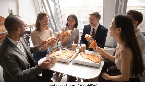 Overjoyed happy mixed race company employees gathered at office table, celebrating special occasion, eating delivery Italian fast food, talking, storytelling, joking, bursting in laugh, having fun. - Powered by Shutterstock