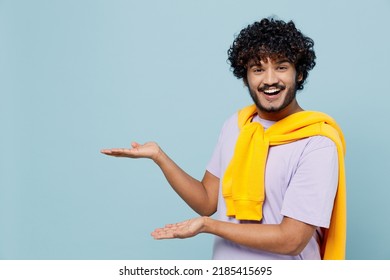 Overjoyed Happy Young Bearded Indian Man 20s Years Old Wears White T-shirt Pointing Hands Palms Away On Workspace Area Copy Space Mock Up Isolated On Plain Pastel Light Blue Background Studio Portrait