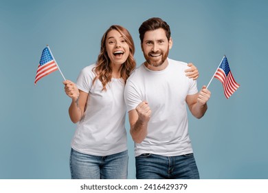 Overjoyed man and woman holding American flags isolated on blue background. Voting, Election day concept  - Powered by Shutterstock