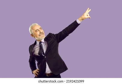 Overjoyed Mature Businessman In Suit Isolated On Purple Studio Background Have Victory Dance. Happy Successful Senior Man Worker Make Dancer Moves Celebrate Success Or Win.