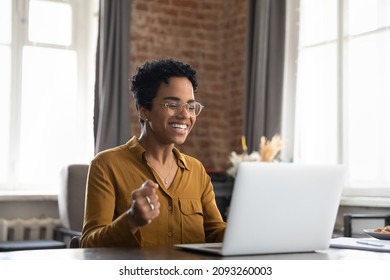 Overjoyed millennial African American woman in eyewear looking at laptop screen, celebrating getting email with amazing news, getting online lottery gambling win notification or dream job offer. - Shutterstock ID 2093260003
